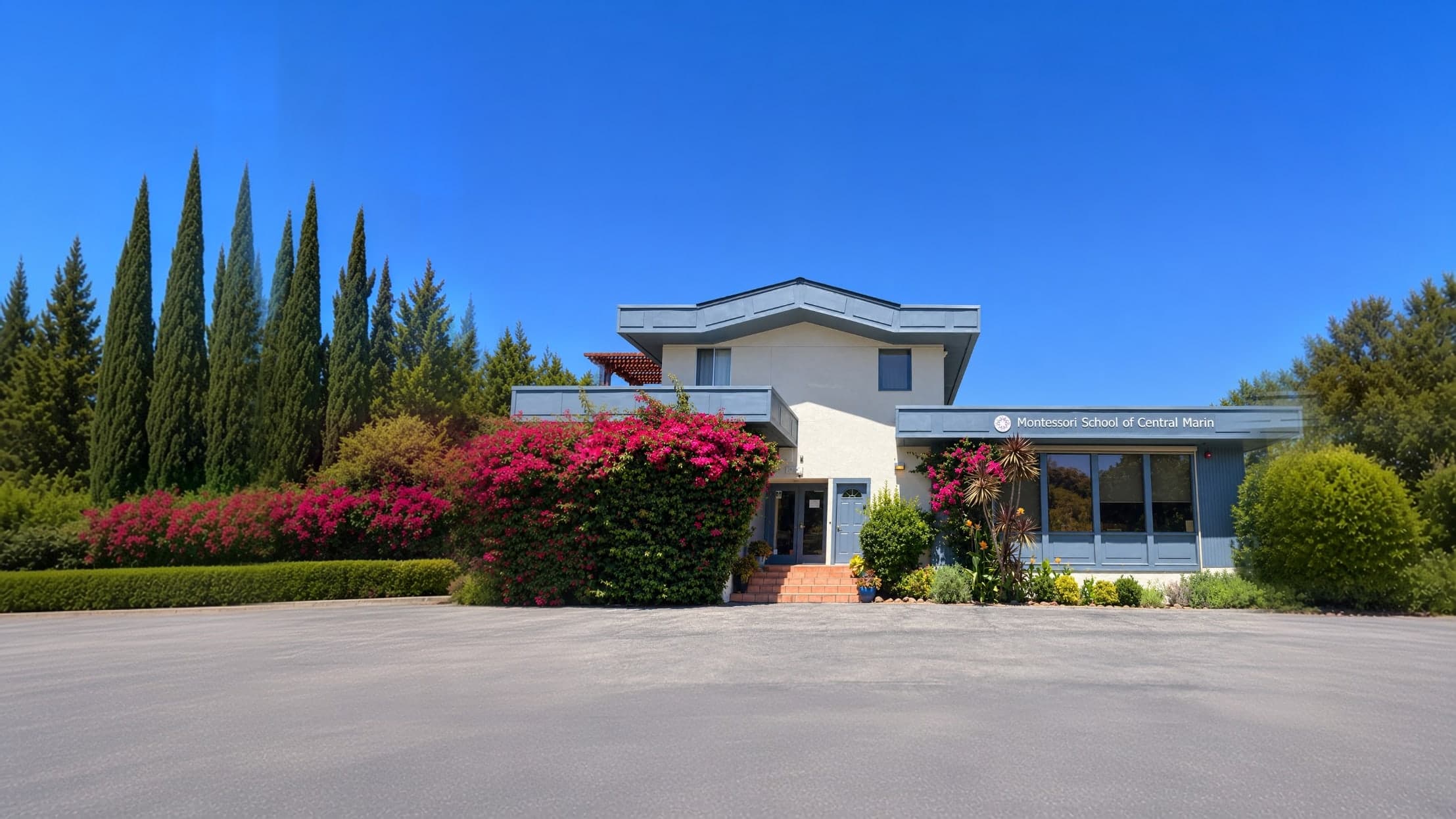 The front of the Montessori School of Central Marin building with its sign and blooming bougainvillea